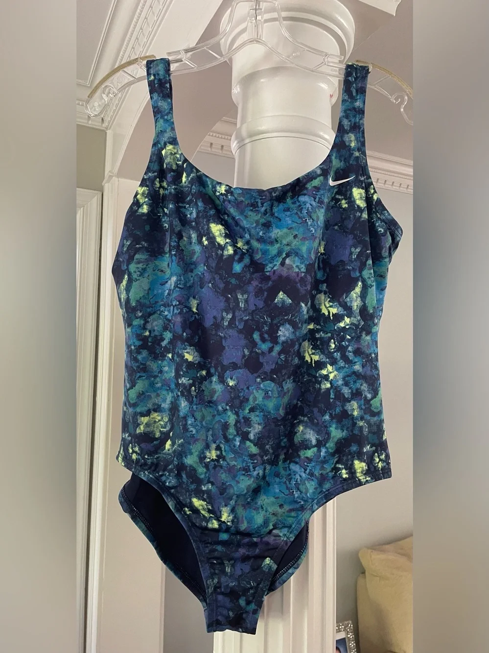 Nike women’s one piece swimsuit abstract watercolors print with a swoosh logo .